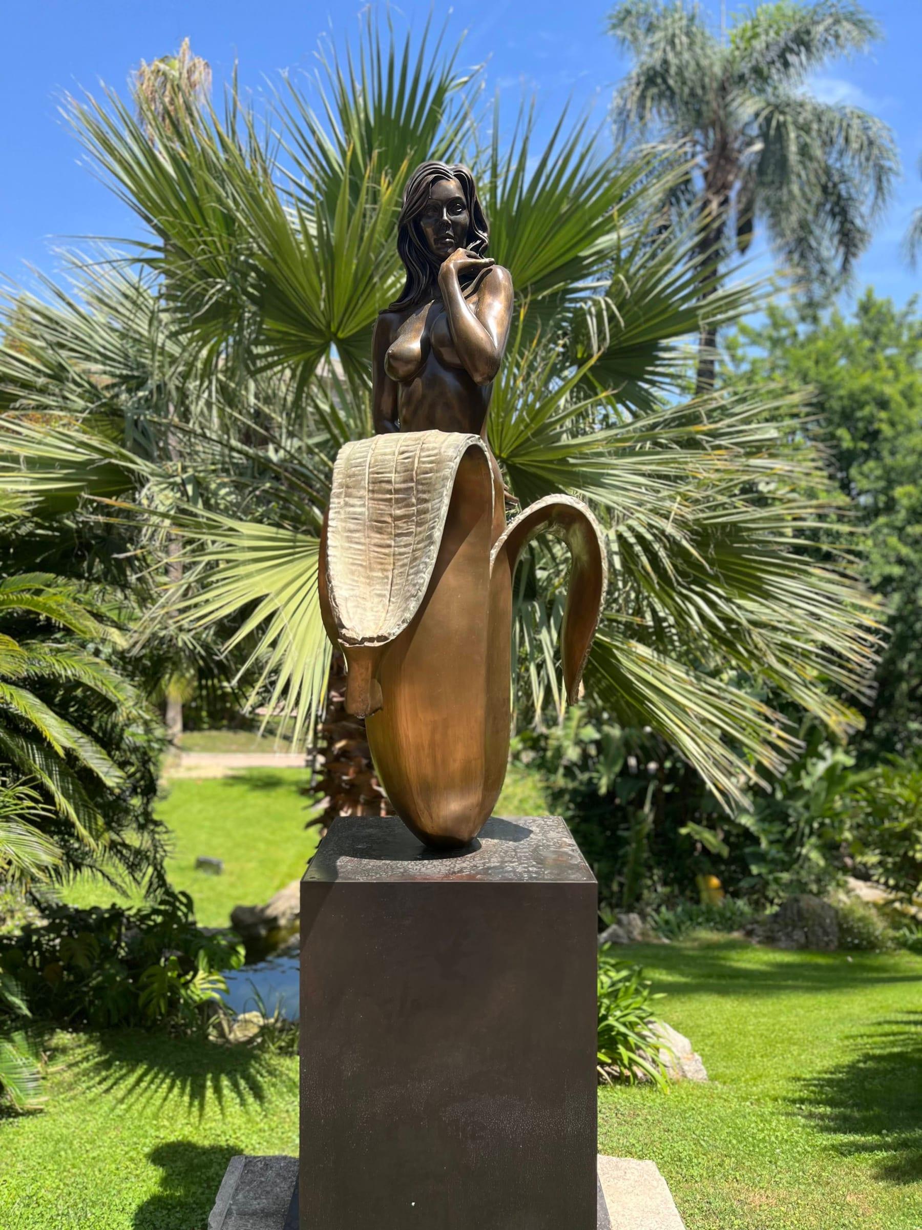 Bronze sculpture in tropical garden with palm trees