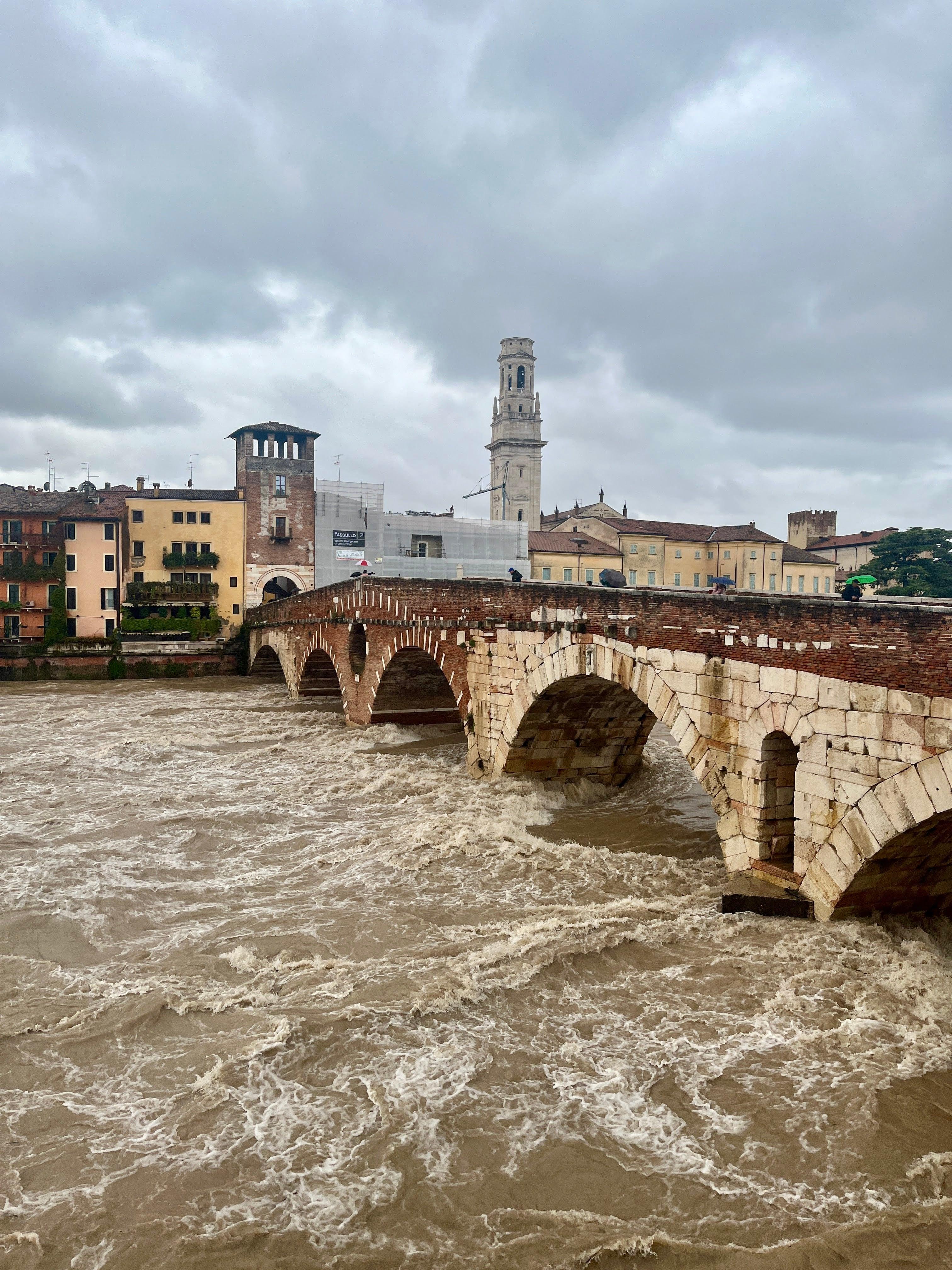 Ponte Pietra stone bridge over a flooded Adige River in Verona