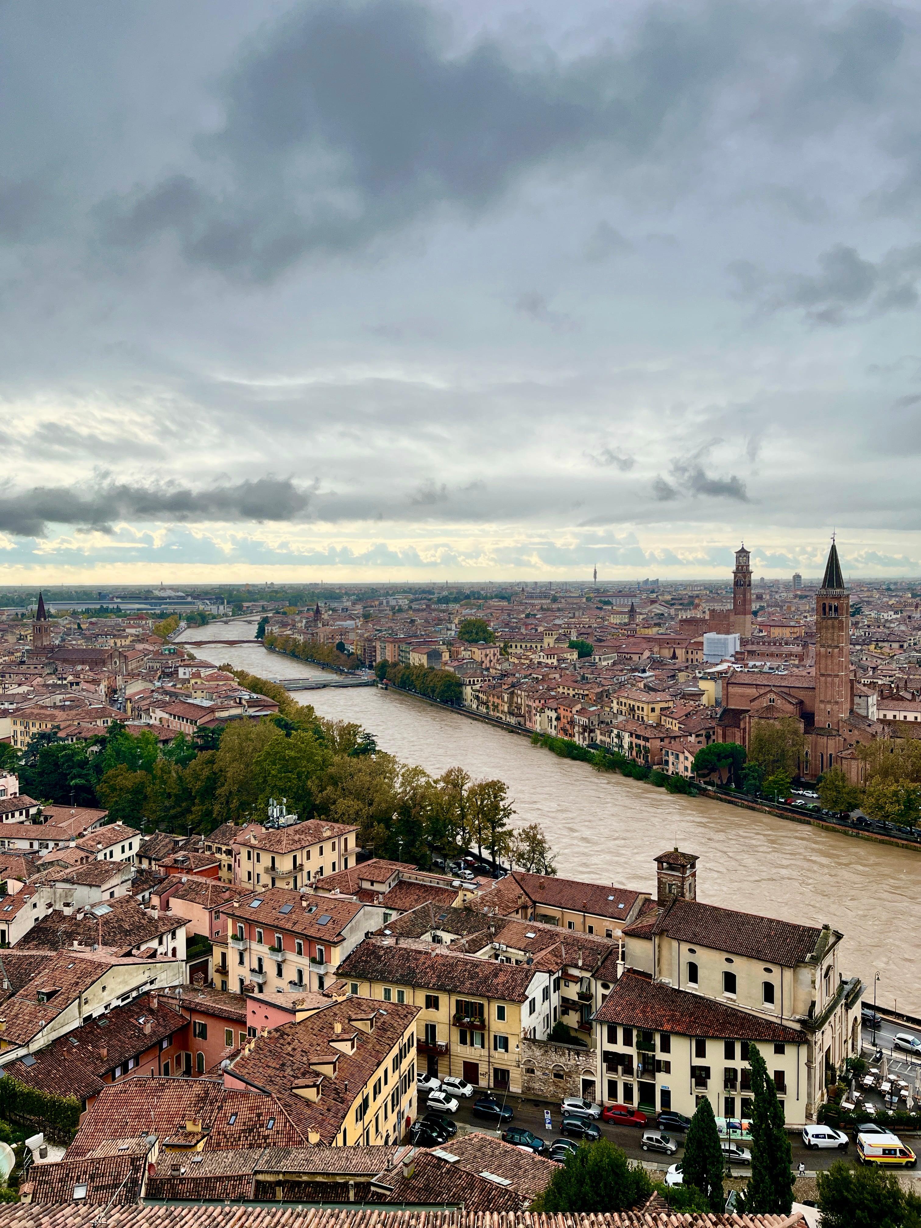 Aerial view of Verona rooftops and Adige River under overcast skies