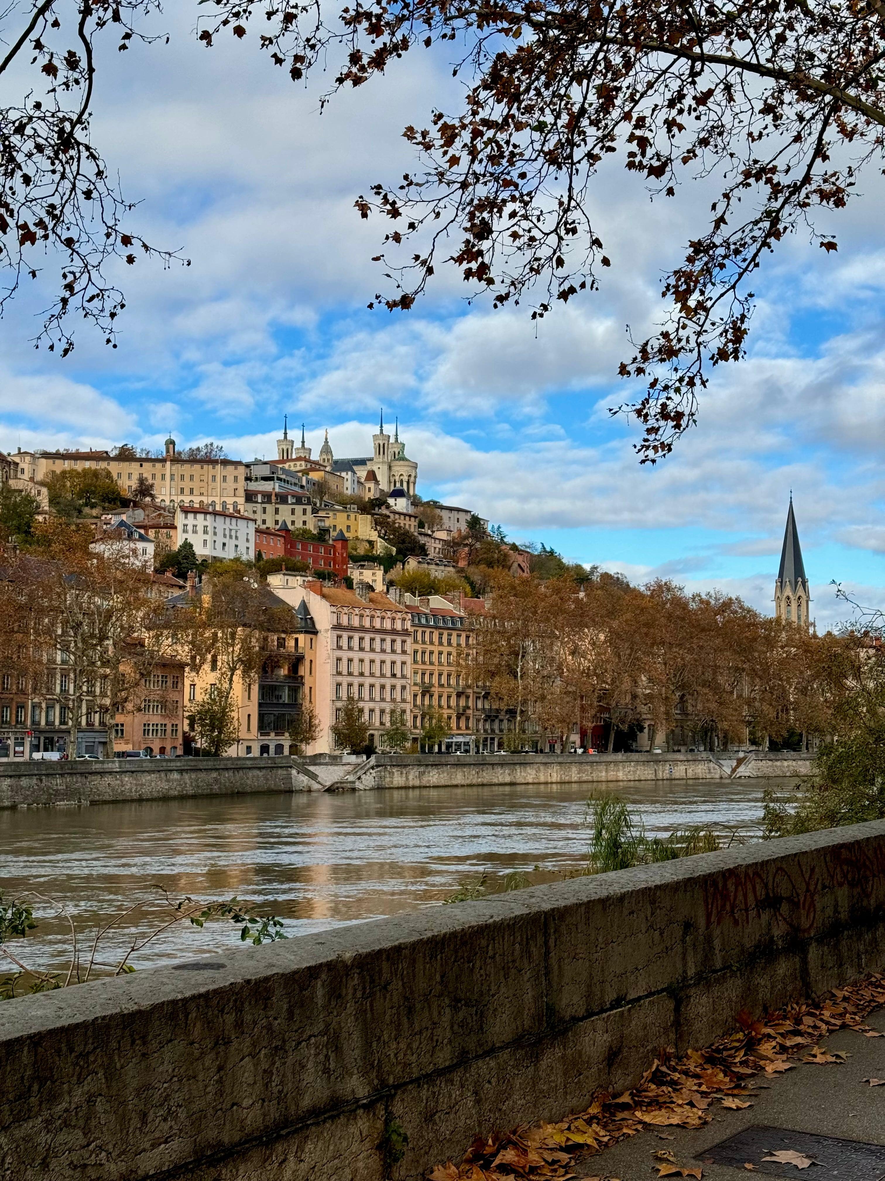 Autumn riverside view of Lyon old town with Fourviere basilica on hill