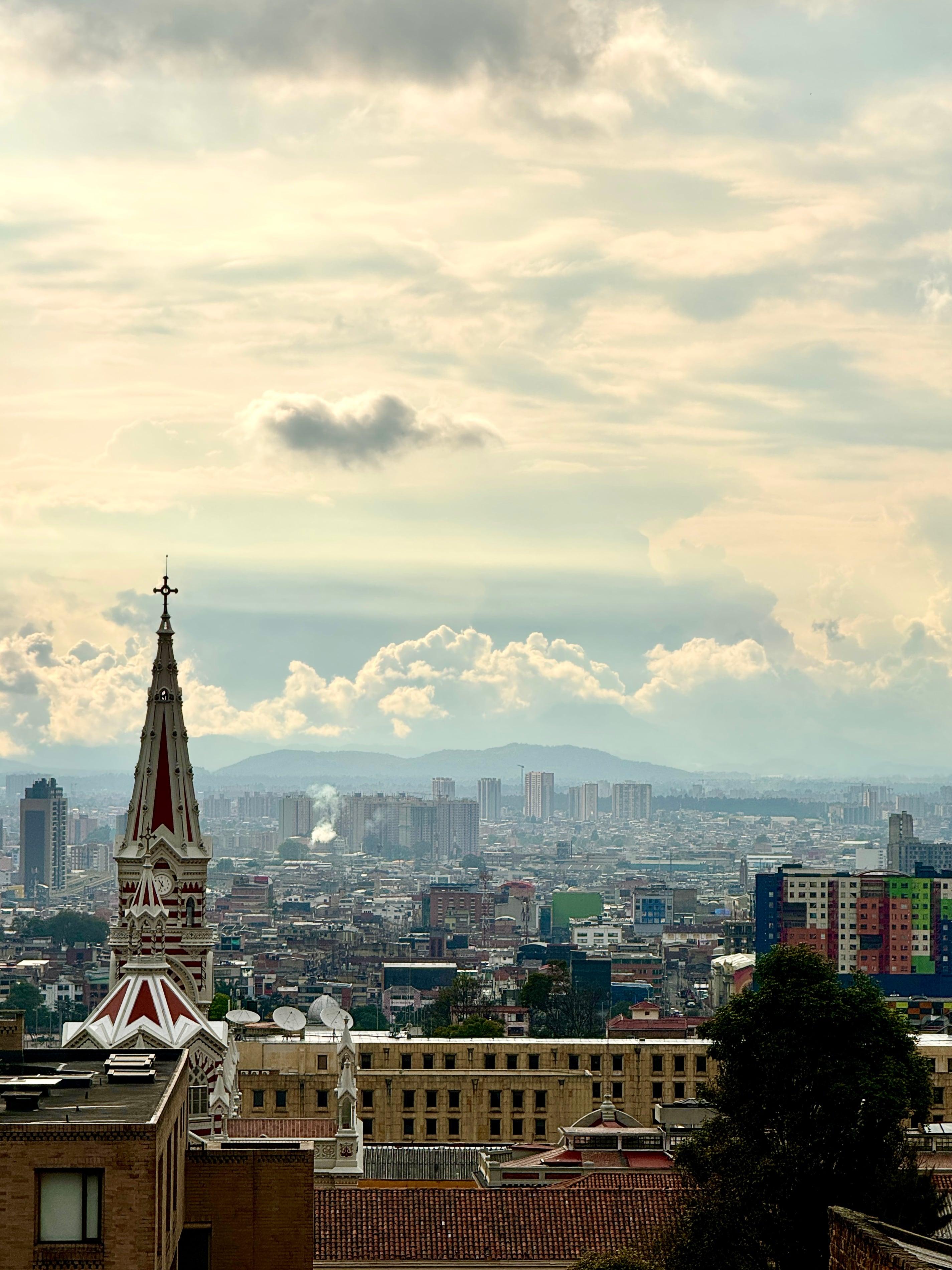 Bogota cityscape with gothic church spire mountains and cloudy sky