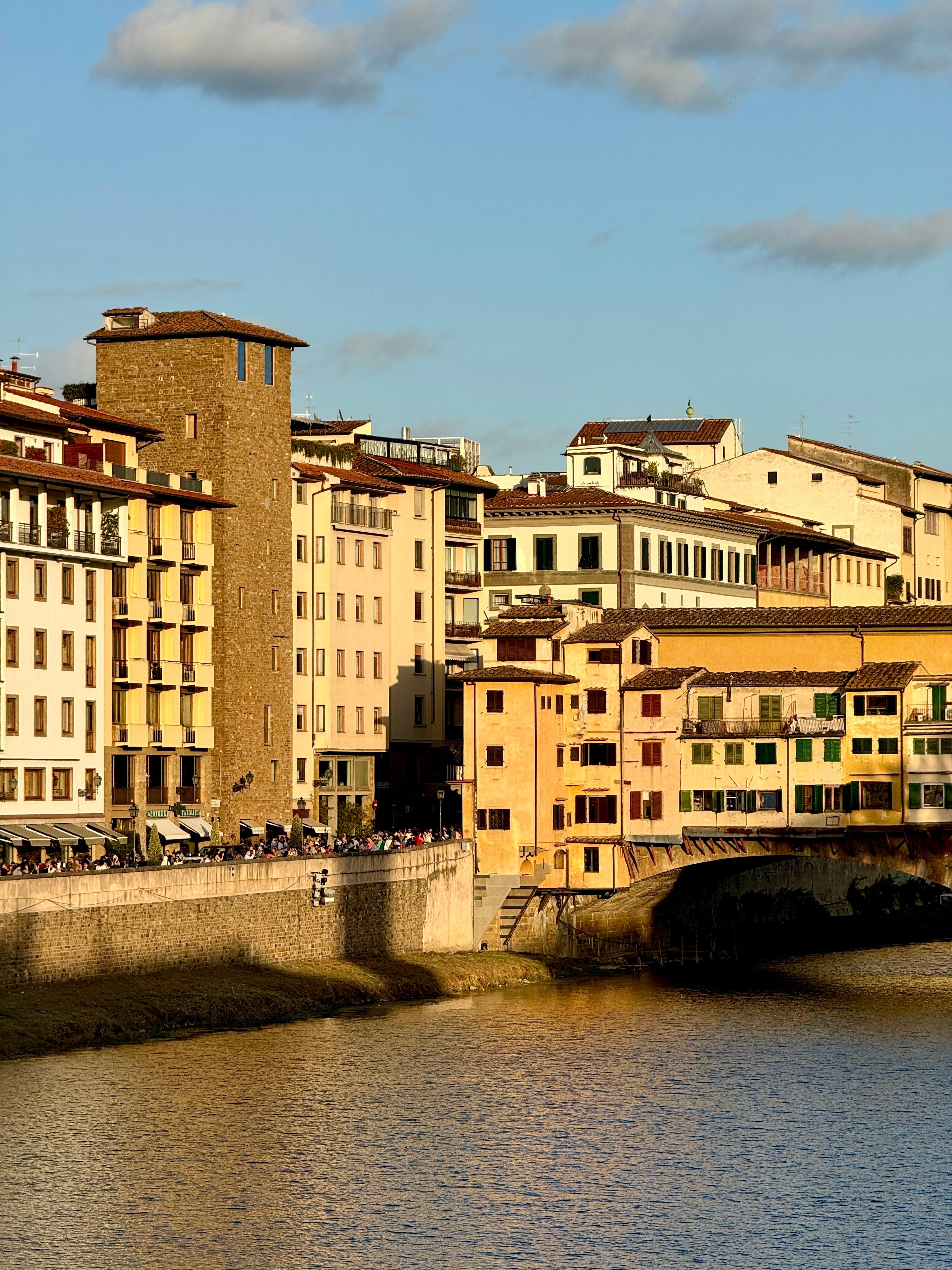 Ponte Vecchio and riverside buildings bathed in golden afternoon light