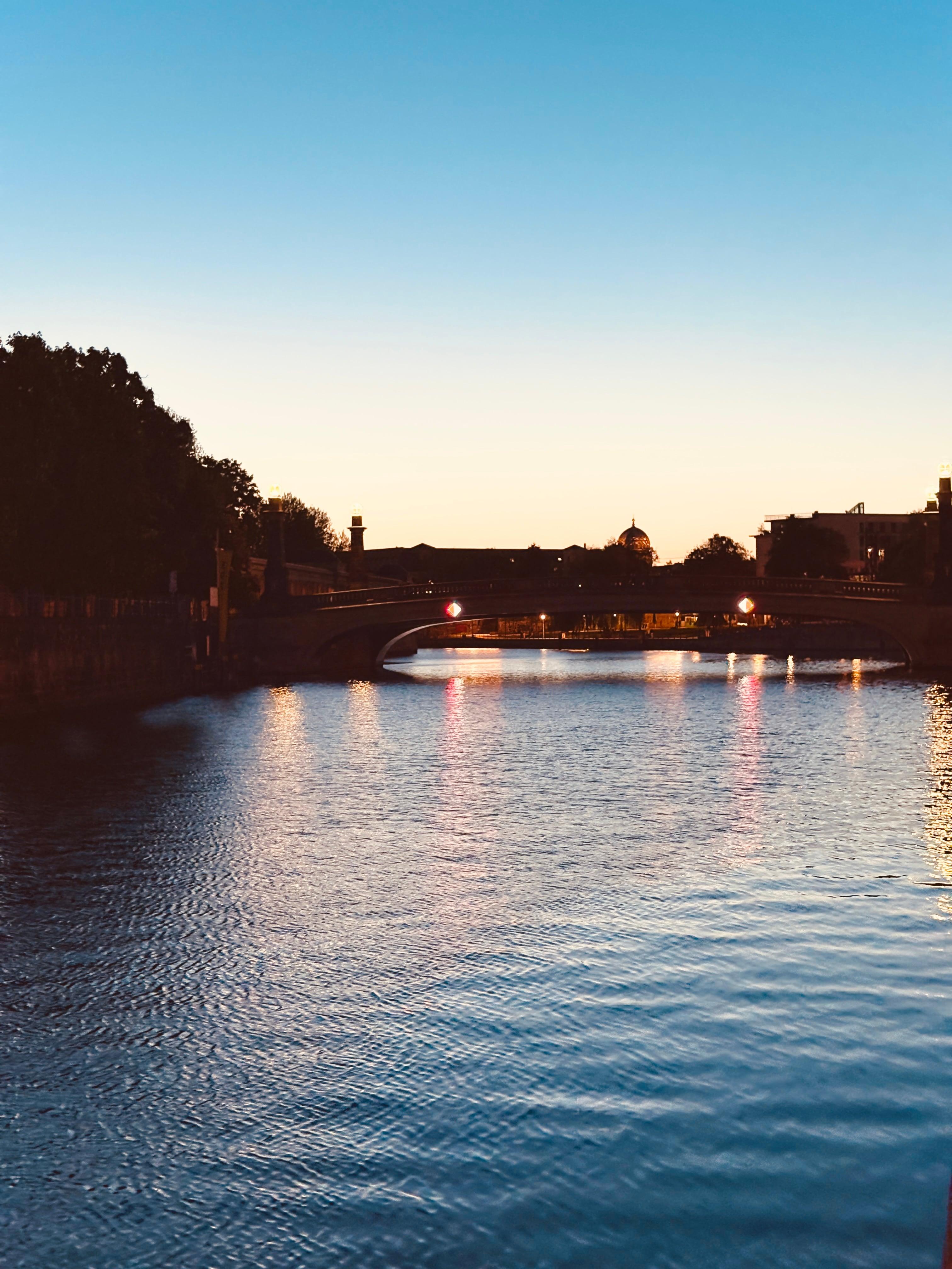 Spree River bridge silhouette with dome at dusk in Berlin